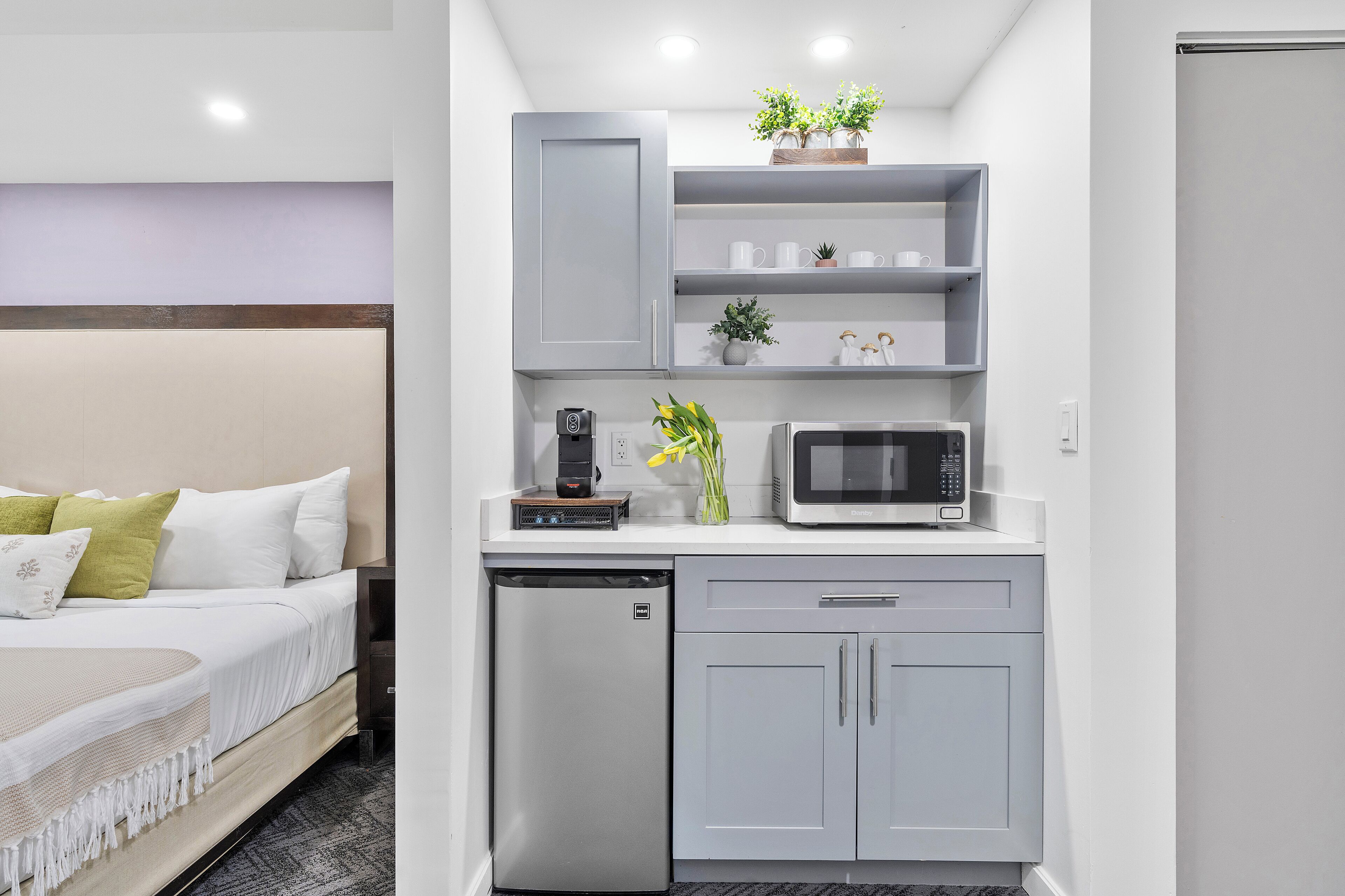 A compact kitchenette with a microwave, a small refrigerator, and a coffee maker.