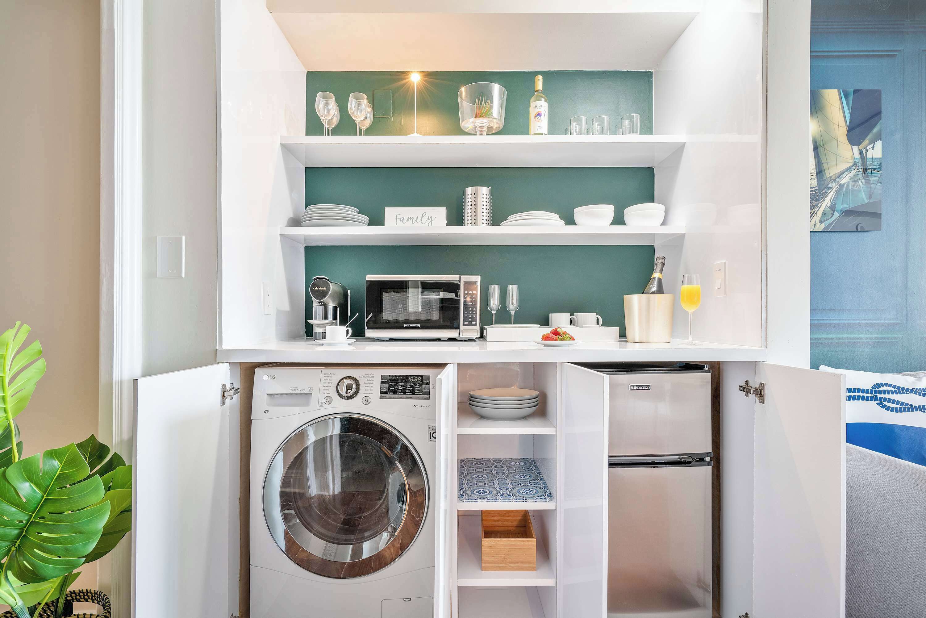 A compact kitchenette with a microwave, coffee maker, and a built-in washing machine.
