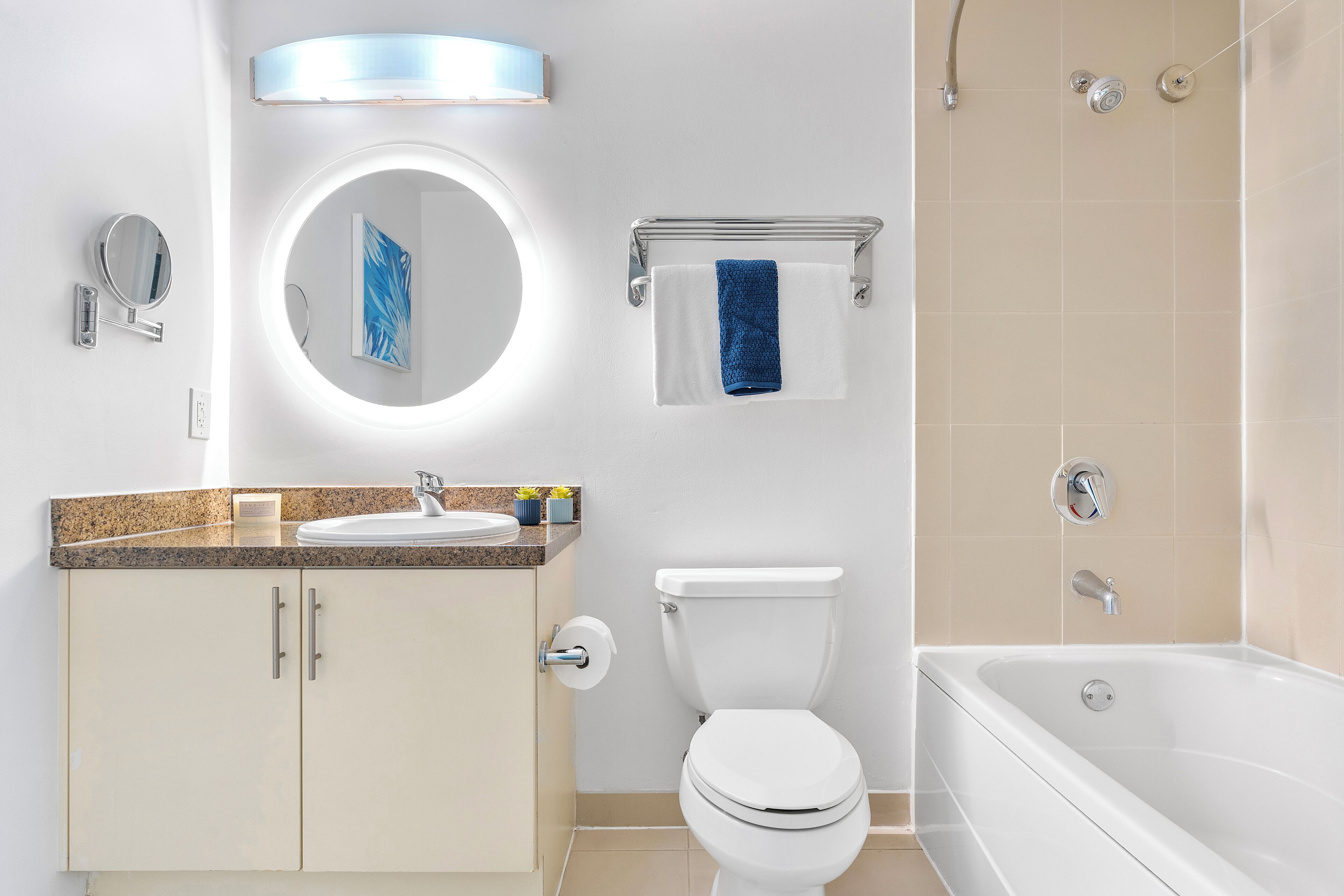 Ein modernes Badezimmer mit Waschbecken, Spiegel, Toilette und Badewanne.