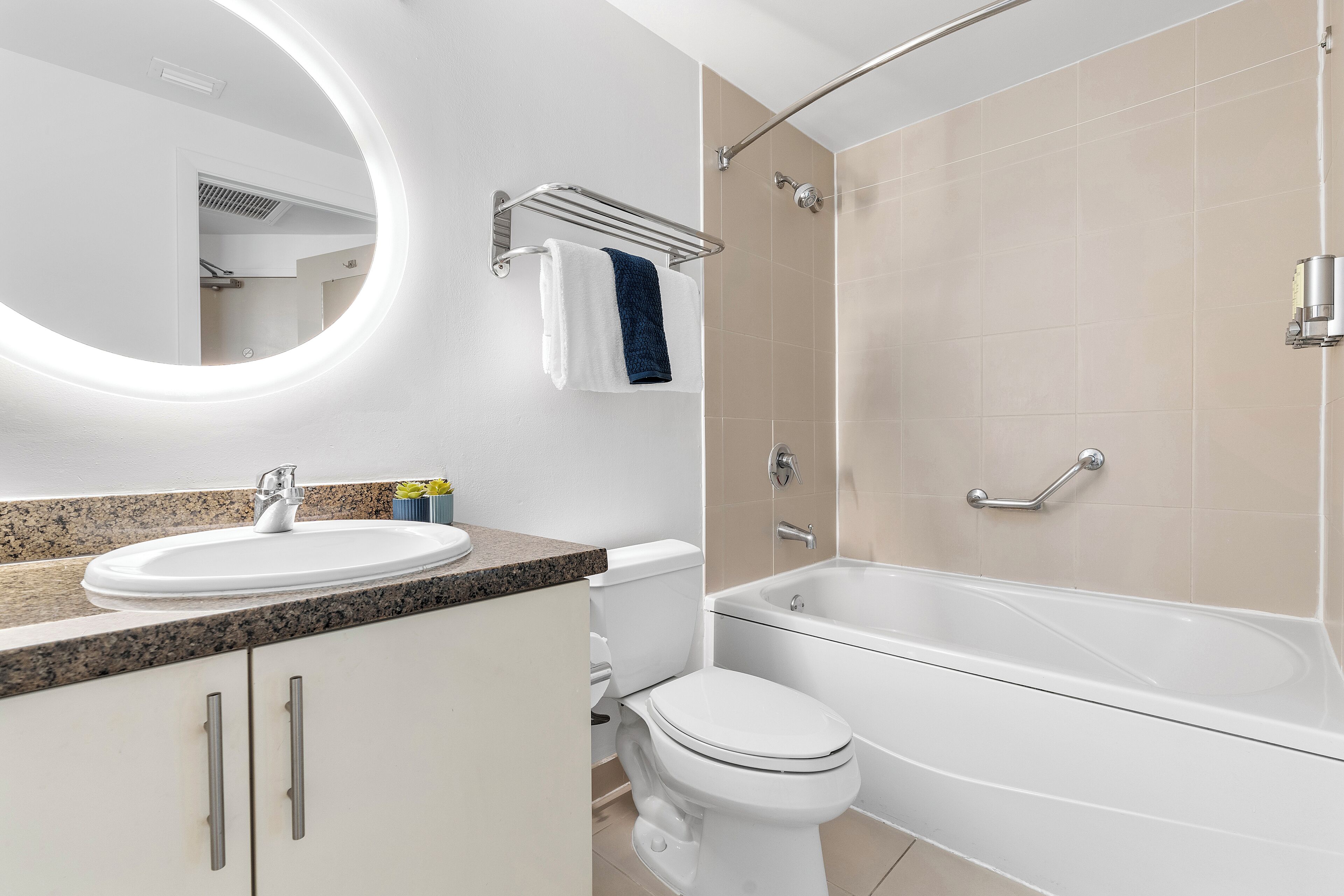 A modern bathroom with a sink, toilet, and bathtub.