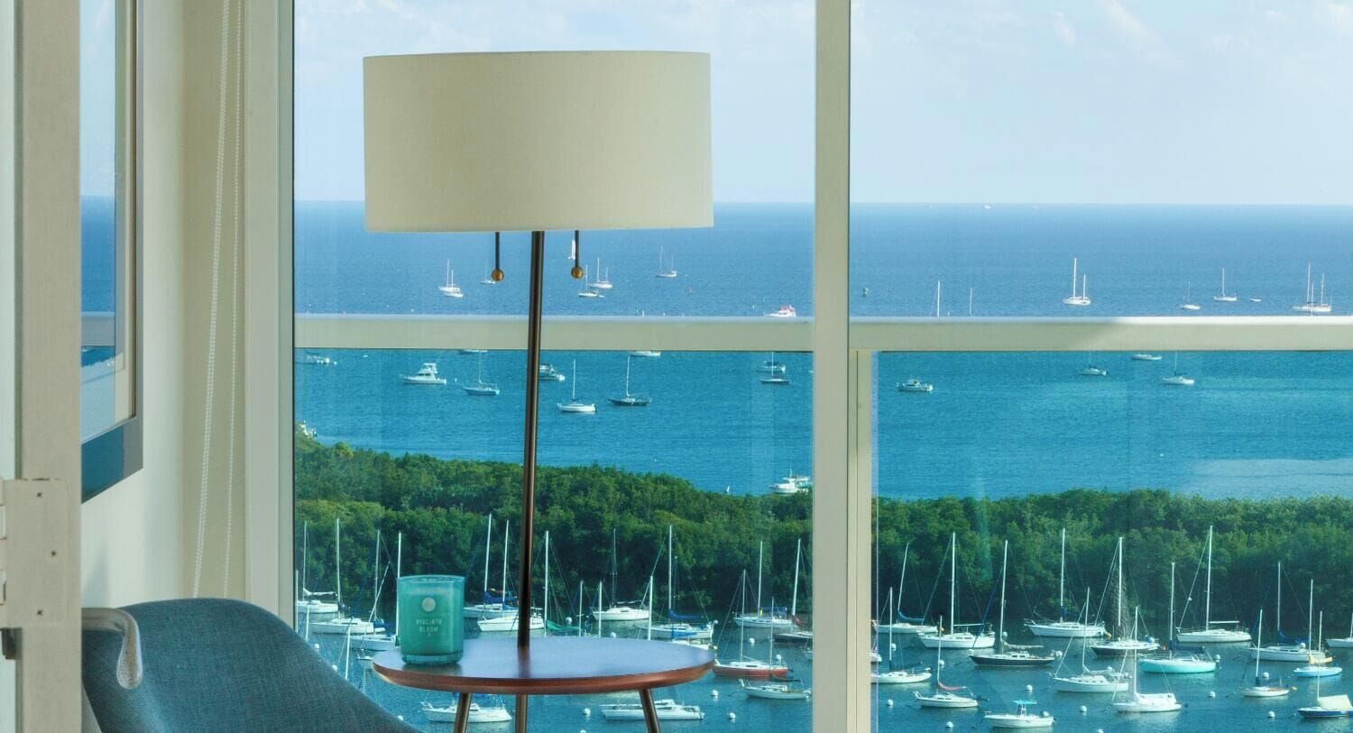 A room with a large window overlooking a marina filled with boats.