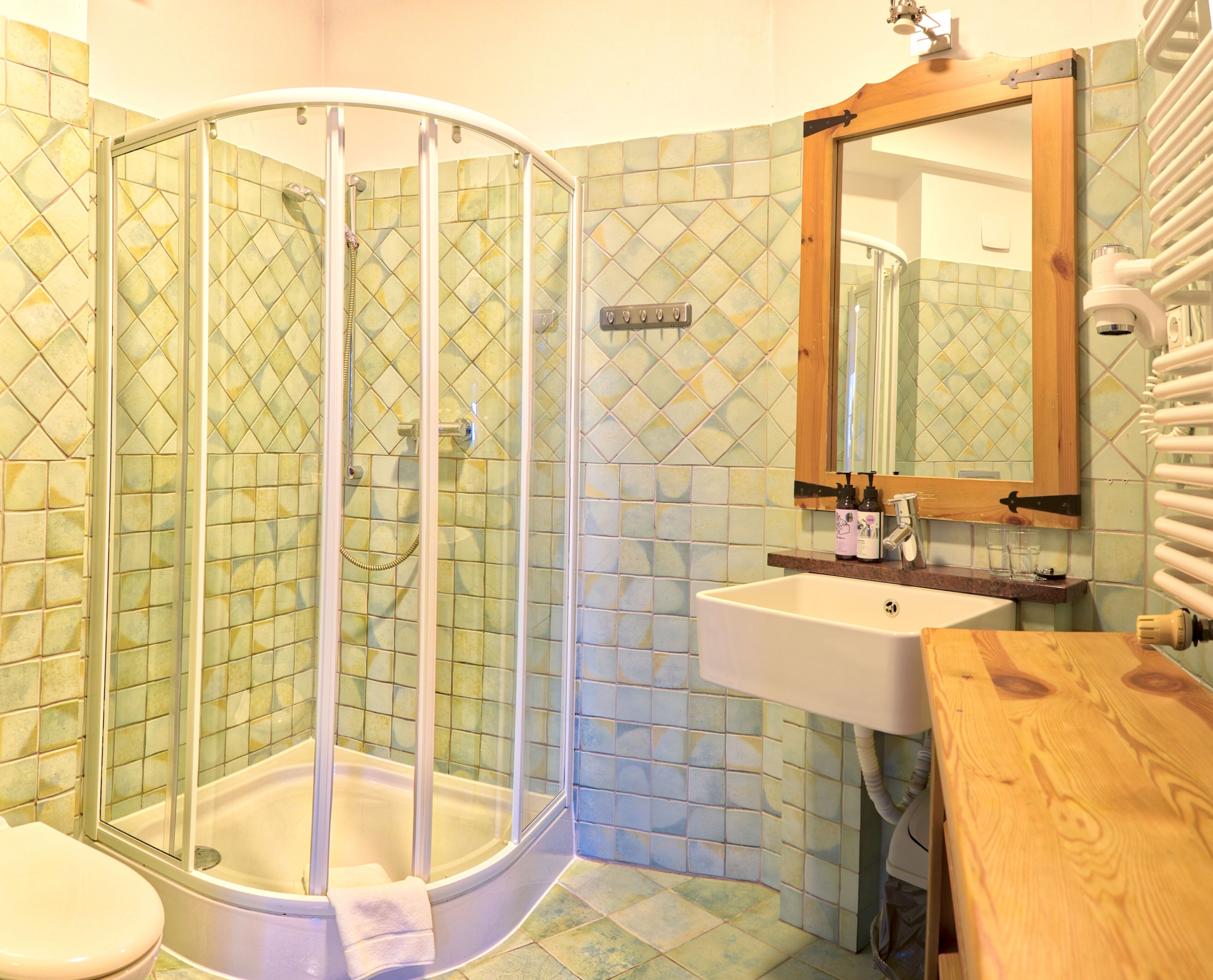 A bathroom with a glass-enclosed shower, a sink, and a wooden vanity.