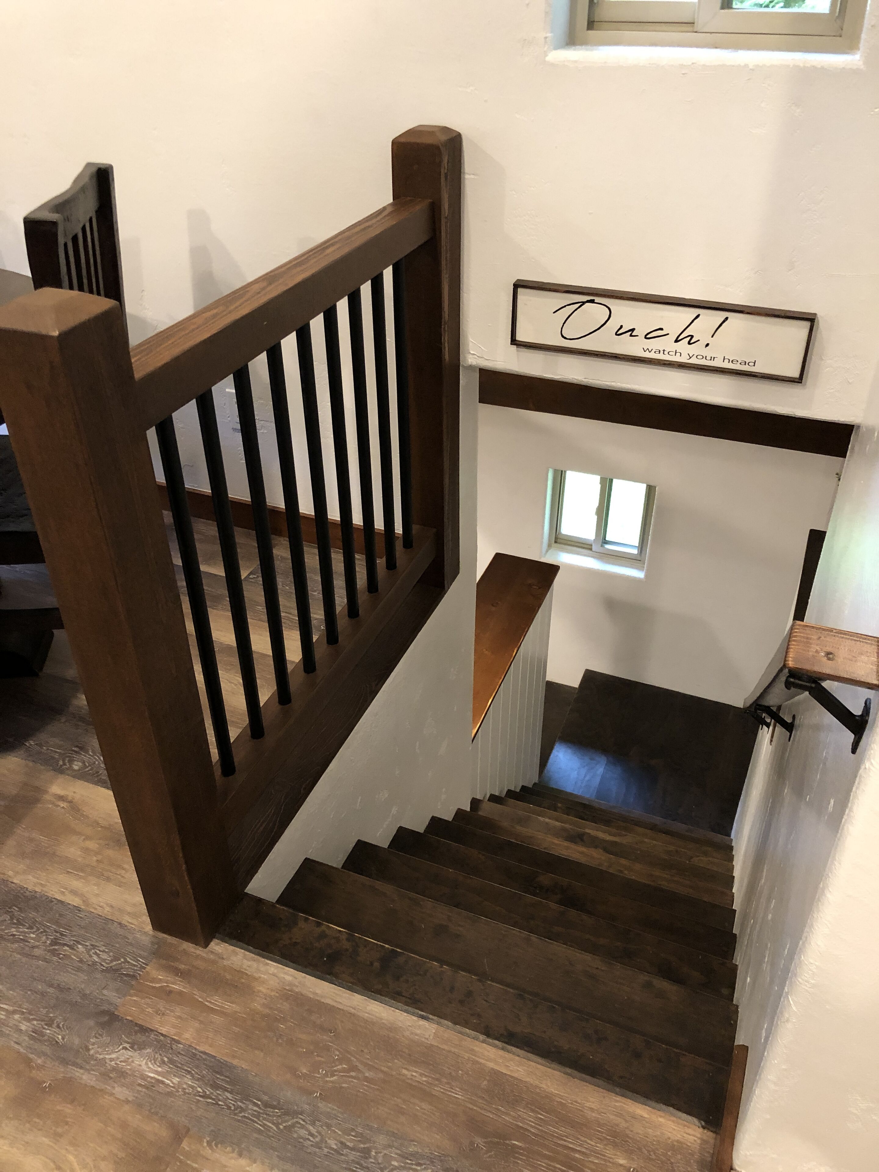 A wooden staircase with a handrail and a sign above it.