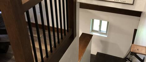 A wooden staircase with a handrail and a sign above it.