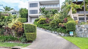 Um edifício moderno com uma entrada portão e uma estrada de paralelepípedos.