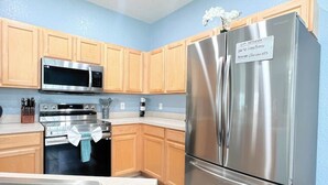 A modern kitchen with wooden cabinets, stainless steel appliances, and a built-in oven.