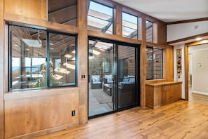 Una habitación amplia con grandes puertas corredizas de vidrio que dan a un patio al aire libre.
