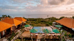 A resort with outdoor seating, a swimming pool, and a view of the sea. - Nusa Sedayu hotel (Penida Island)