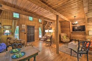 Cozy cabin-style room with a wooden ceiling, flat-screen TV, and comfortable seating area.