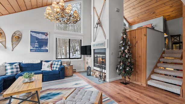 Una sala de estar acogedora con un sofá azul, una mesa de centro de madera y una chimenea.