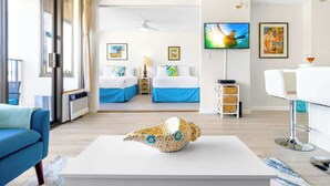 Een hotelkamer met twee bedden, een televisie, kunstwerken en een uniek sculptuur op een tafeltje.