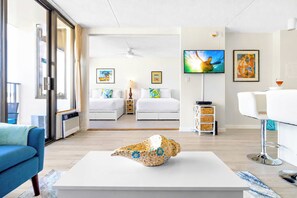 Een moderne hotelkamer met een groot bed, een bureau, een televisie en kunstwerken aan de wanden.