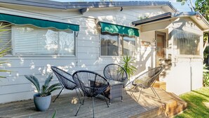A house with a covered porch, two chairs, and a potted plant. - Seaward, Werri Beach - Gerringong (Werri Beach)