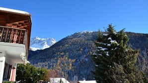 Vista de la montaña con un balcón de madera que domina un pico nevado.