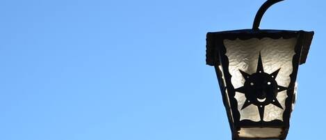 Eine Straßenlampe mit einem sternförmigen Glaskopf vor blauem Himmel.