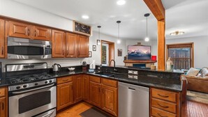Una cocina moderna con armarios de madera, electrodomésticos de acero inoxidable y lavavajillas integrado.