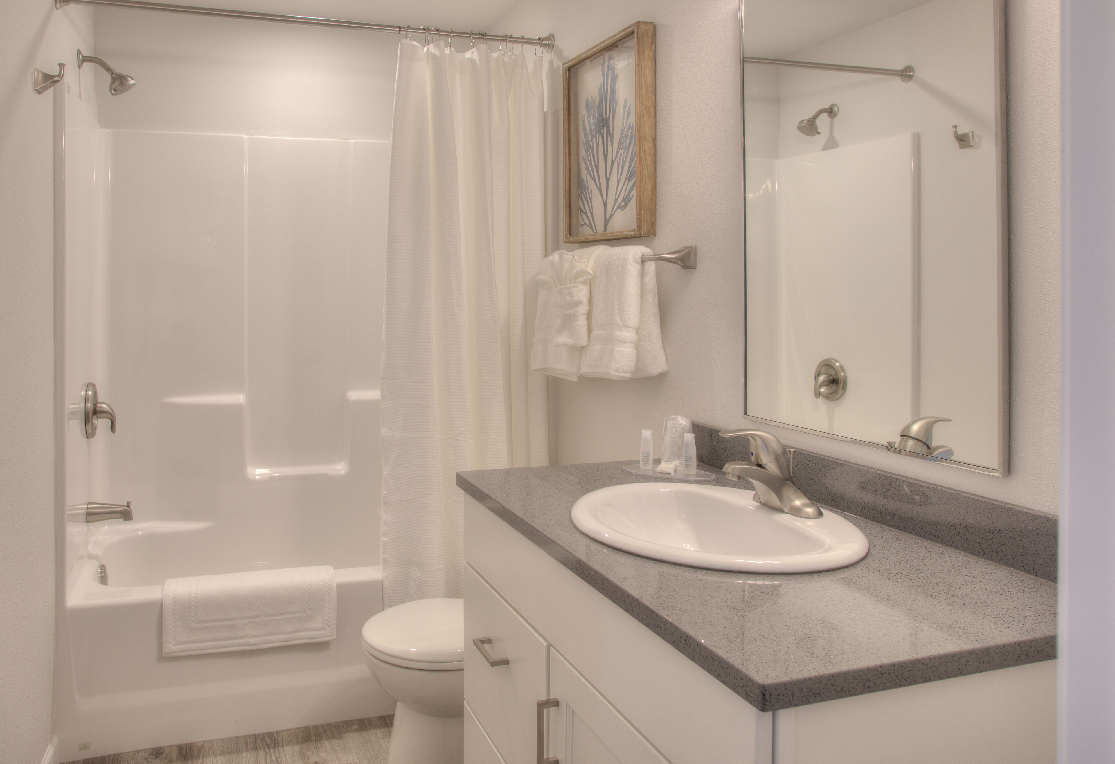 A modern bathroom with a bathtub, toilet, and sink.