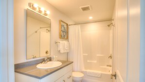 A bathroom with a sink, mirror, and shower. - Americas Best Value Inn Ocean Shores (Ocean Shores)