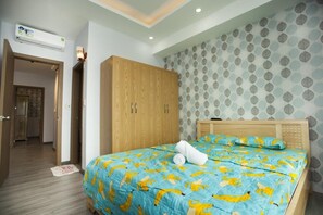 Ein Schlafzimmer mit Bett, Holzschrank und gemustertem Wandpapier.