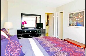 Relax in this serene bedroom with a large bed, dresser, and flat-screen TV.