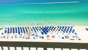 A beach with numerous umbrellas and people. - 18th Floor Pelican Beachfront with Ocean View (Destin)