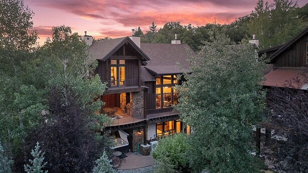 A multi-story wooden house with a balcony and a stone fireplace. - Stunning W/Mountain Views + Hot Tub + Close to Skiing - Overlook Chalet (Steamboat Springs)
