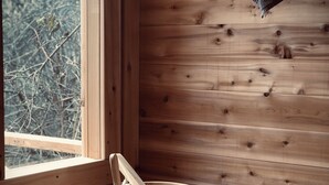 A wooden interior with a window, a wooden bucket, and a wooden spoon.