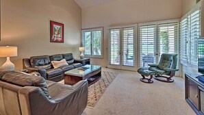 A spacious living room with a leather sofa, a green armchair, and a coffee table. - 259250 3 BR La Quinta Mtn Resort Golf Course Home (La Quinta)