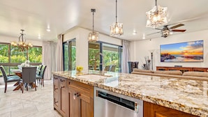 A spacious kitchen with granite countertops, stainless steel appliances, and a large island. - Maui Resort Rentals: Kaanapali Alii 113 – Expansive 3BR Ground-floor Residence, Luxuriously Remodeled, Steps to the Beach! (Lahaina)