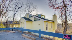 A yellow building with a blue fence and a 'NO PARKING' sign. - Furnished Porch! Margaritaville Resort Family Stay (Osage Beach)