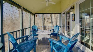 A covered porch with blue Adirondack chairs, a table, and a ceiling fan. - Furnished Porch! Margaritaville Resort Family Stay (Osage Beach)