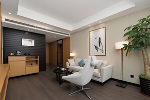 A modern hotel lobby with a reception desk, a sofa, a coffee table, a floor lamp, and a potted plant. - Yiho Hotel (Fuzhou South Railway Station)  (Fuzhou)