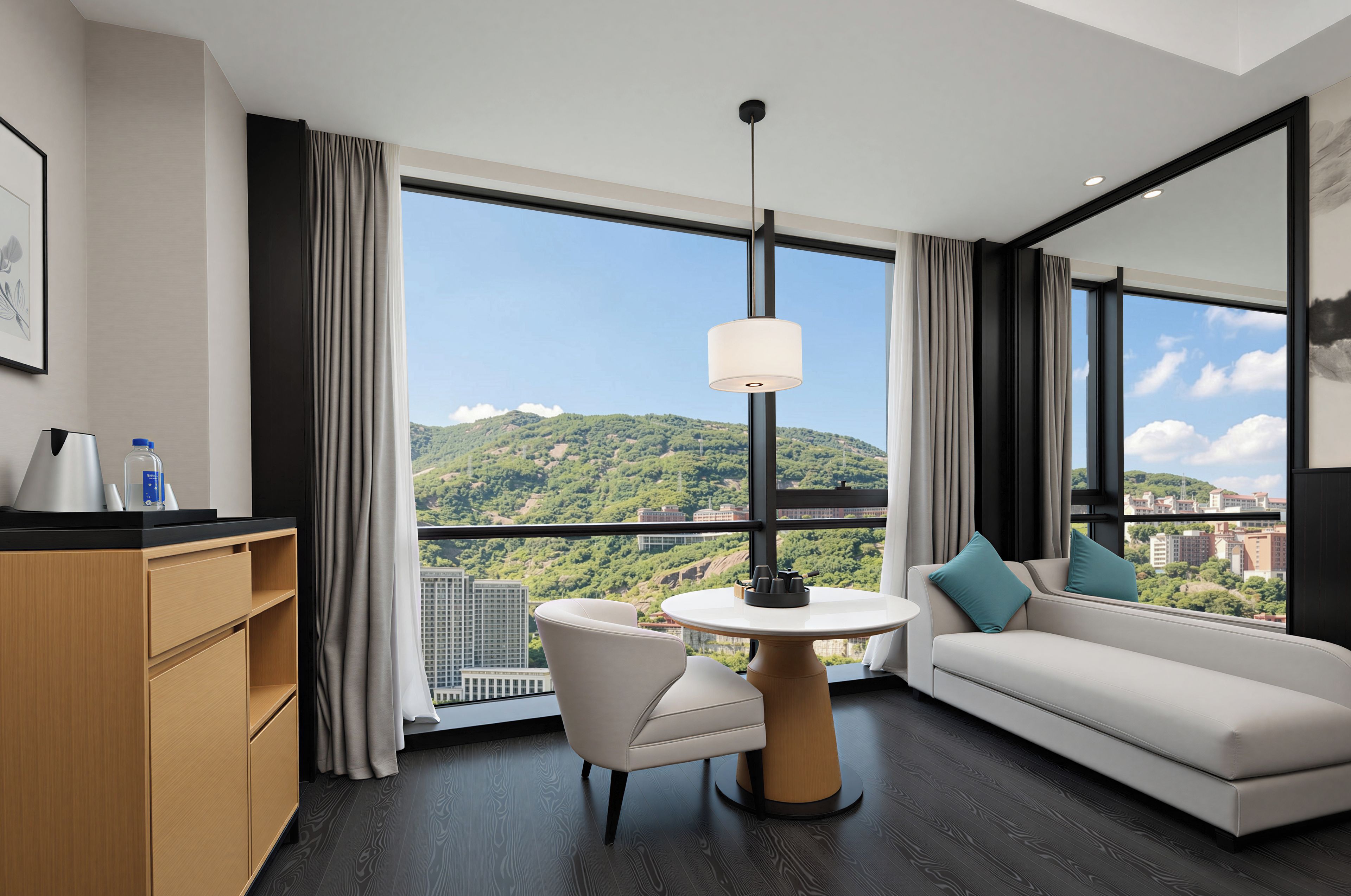 Une chambre d’hôtel moderne avec une grande fenêtre, une table ronde, un canapé et un meuble.