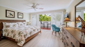 Une chambre à coucher comprenant un lit, une commode, une chaise, un ventilateur de plafond et une vue sur l’extérieur.
