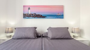 Una cama con dos almohadas y una mesita de noche con una lámpara.