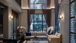 A spacious lobby with a geometric patterned floor, a chandelier, and a seating area with sofas and a coffee table. - Charmaine's Hotel & Apartment (Ho Chi Minh City)