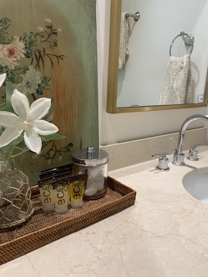 Bathroom features a vanity with a countertop, a mirror, and a decorative wall panel.
