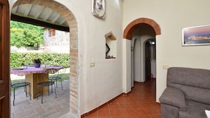 Un intérieur comprenant un patio, une table à manger avec des chaises, un canapé et une vue sur l’extérieur.