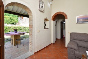 An interior with a patio area, a dining table with chairs, a sofa, and a view of the outside. - La Badia 2, Tavarnelle Val di Pesa, Italy (Tavarnelle Val di Pesa)