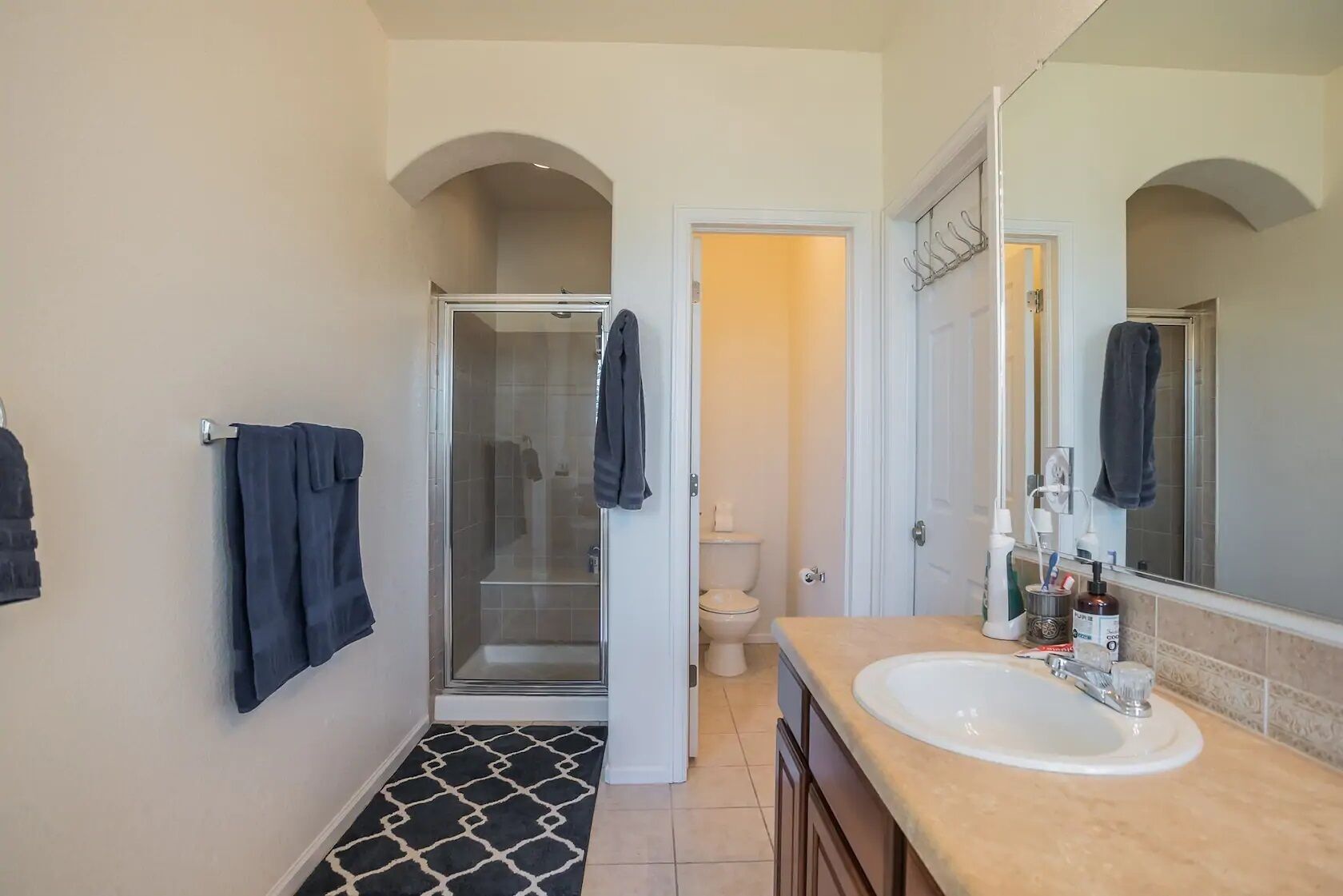 A bathroom with a shower, toilet, and sink.