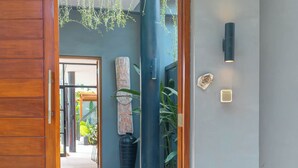 Puerta de madera que da a un pasillo con un letrero que dice "VILLA BOA" y una planta en maceta.