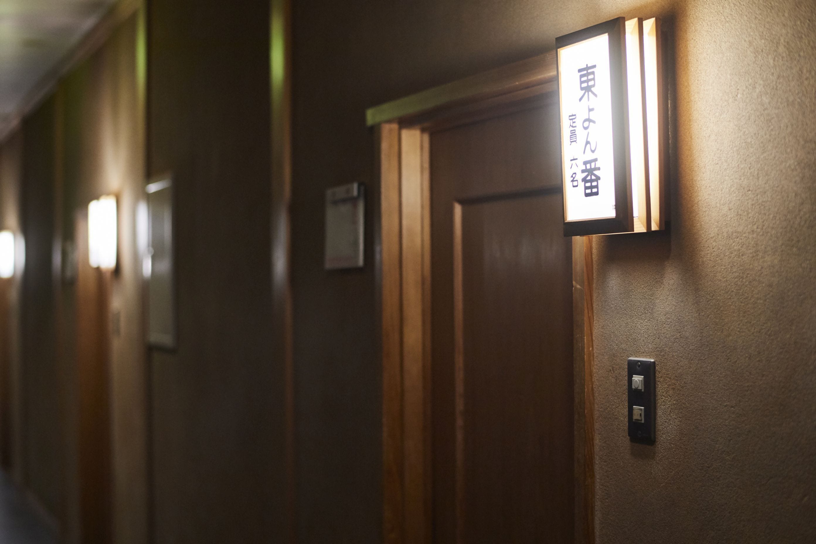 A hallway with wooden doors and a sign indicating room number 101.