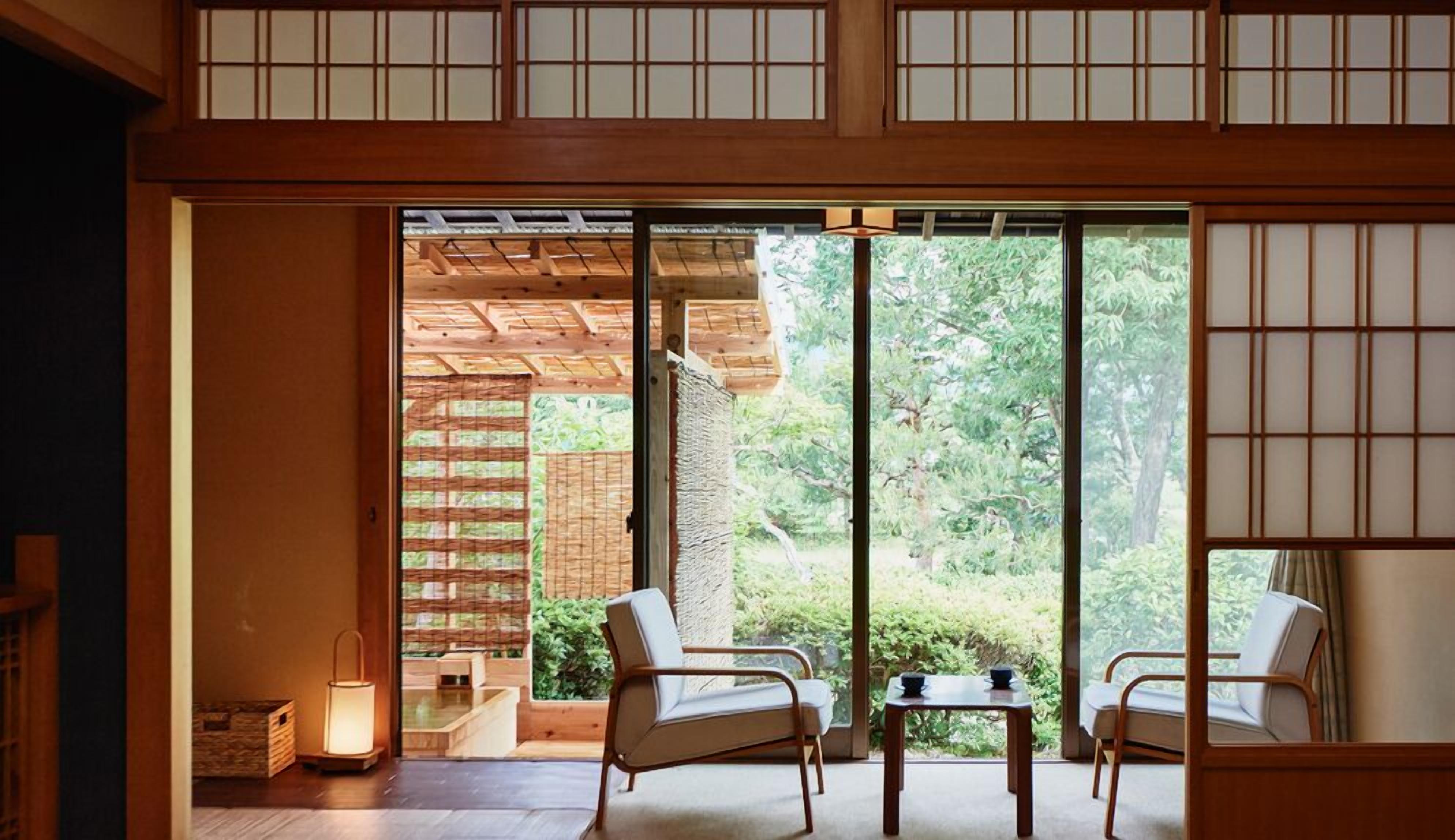 A traditional Japanese room with tatami flooring, sliding doors, and a view of a garden.