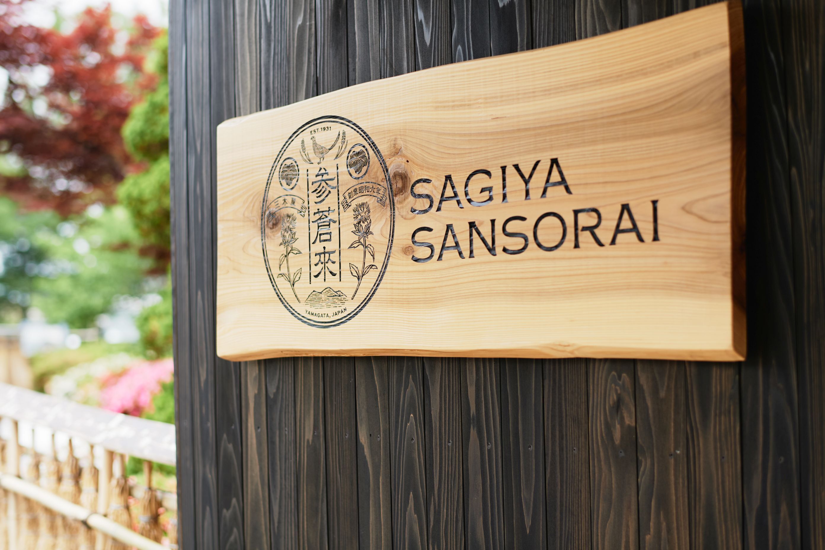 Ein Holzschild mit dem Namen "SAGIYA SANSORAI" und einem Logo mit japanischen Schriftzeichen.