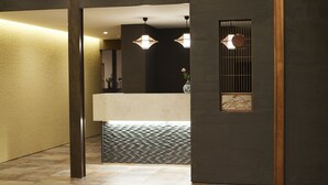 A modern interior with a reception desk, patterned floor, and decorative lighting. - Sagiya Sensorai (Kaminoyama)