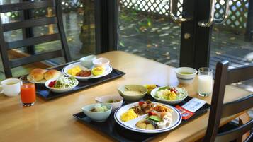 A dining table with various dishes, including salads, meats, and bread, set for a meal.