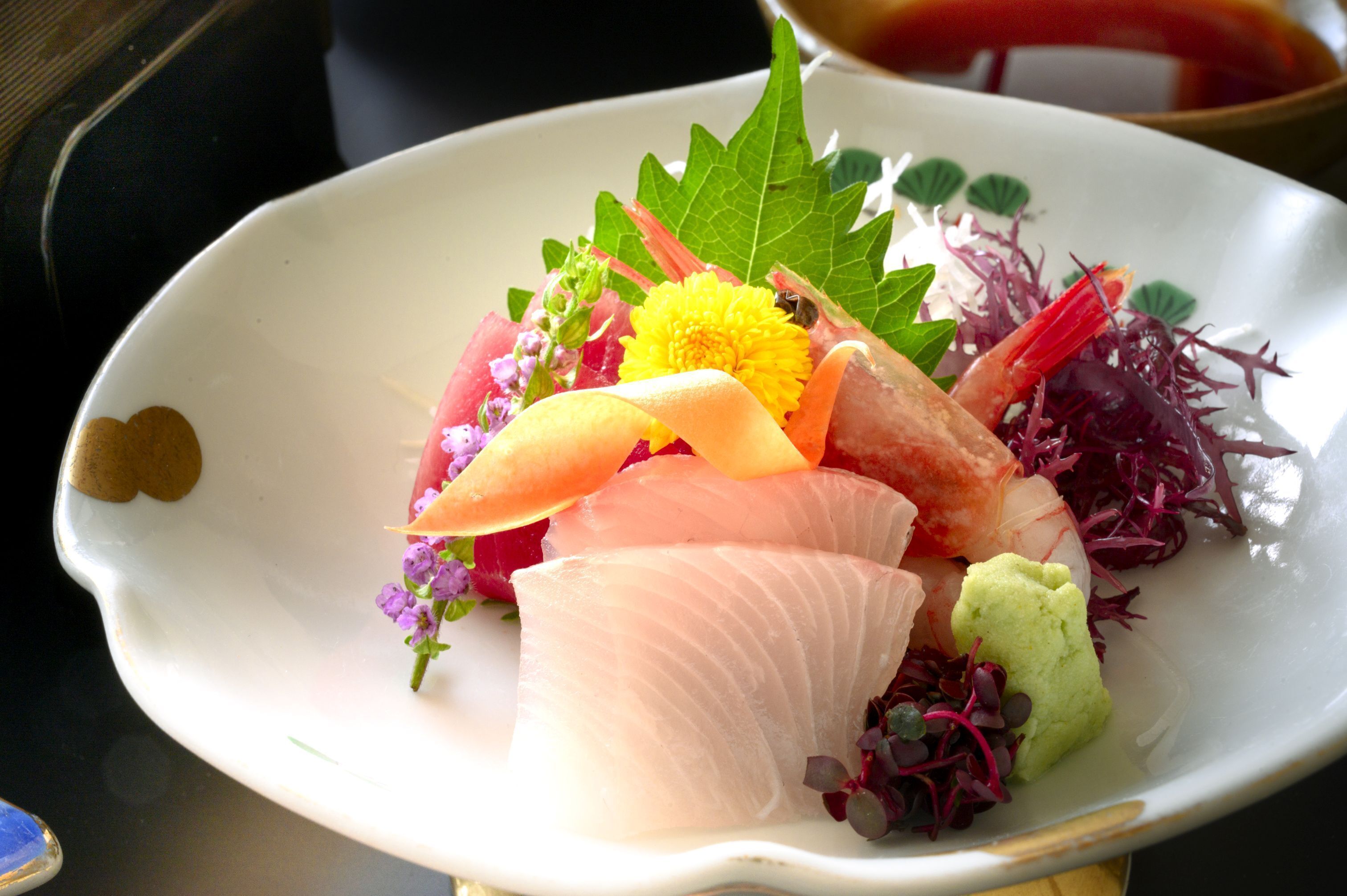 A plate of sashimi with various garnishes.