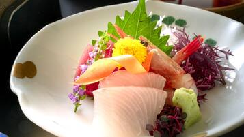 A plate of sashimi with various garnishes.