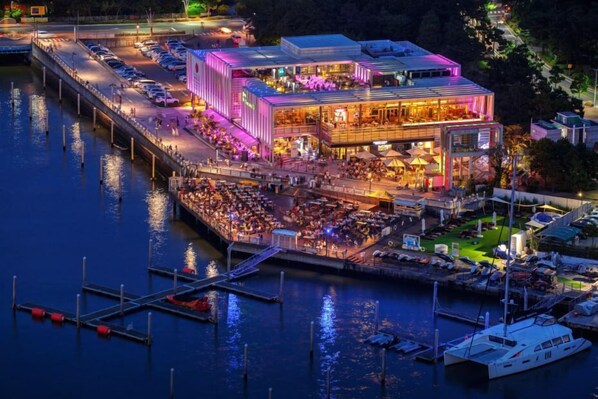 Un hotel sul lungomare con diverse aree ristorazione e un molo.