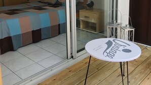 Makuuhuoneessa on sänky, yöpöytä, pöytä ja lasiliukuovi, joka johtaa parvekkeelle.